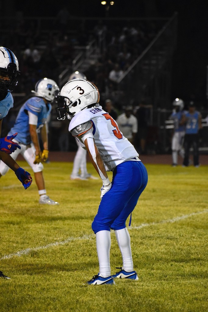 Football player bending with his hands on his knees on field 