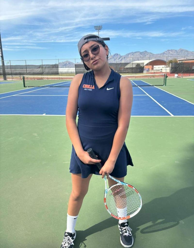 female student in tennis dress posing