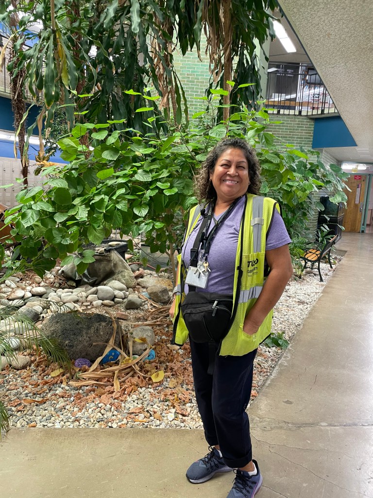 short Hispanic lady .old. Curly short hair wearing a vest  